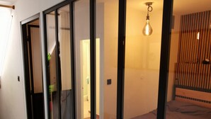 A modern room with large windows, a bed, and a hanging light fixture.