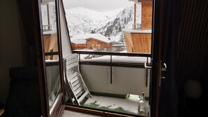 A room with a large window overlooking a snowy mountain landscape.