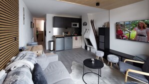 A modern living room with a sofa, a coffee table, and a TV mounted on the wall.