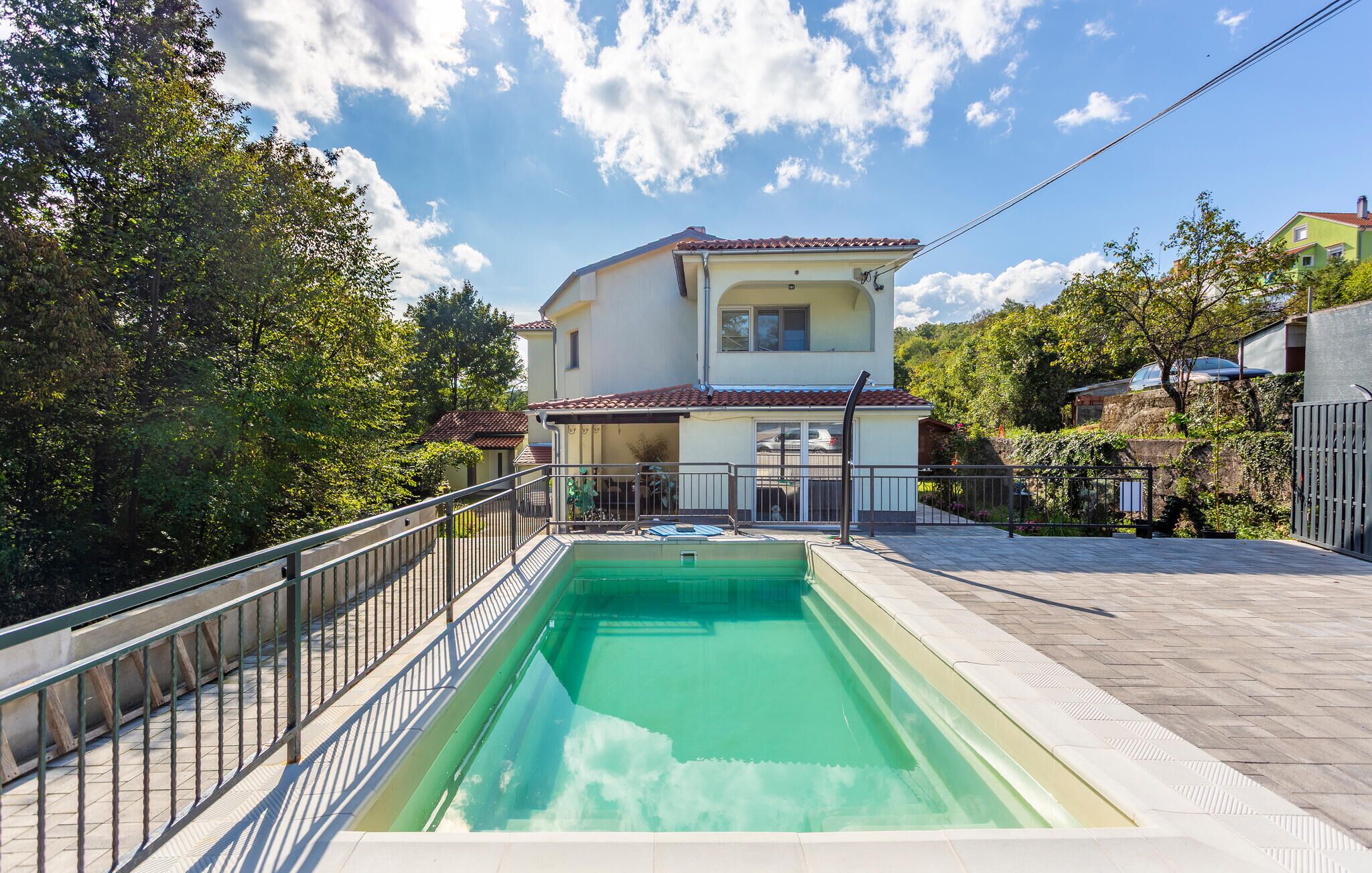 A two-story house with a swimming pool in the backyard.