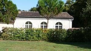 A white building with a tiled roof and three arched windows. - Charming Cottage with Private Gardens, Baby Gear, Near Cognac (Cognac)