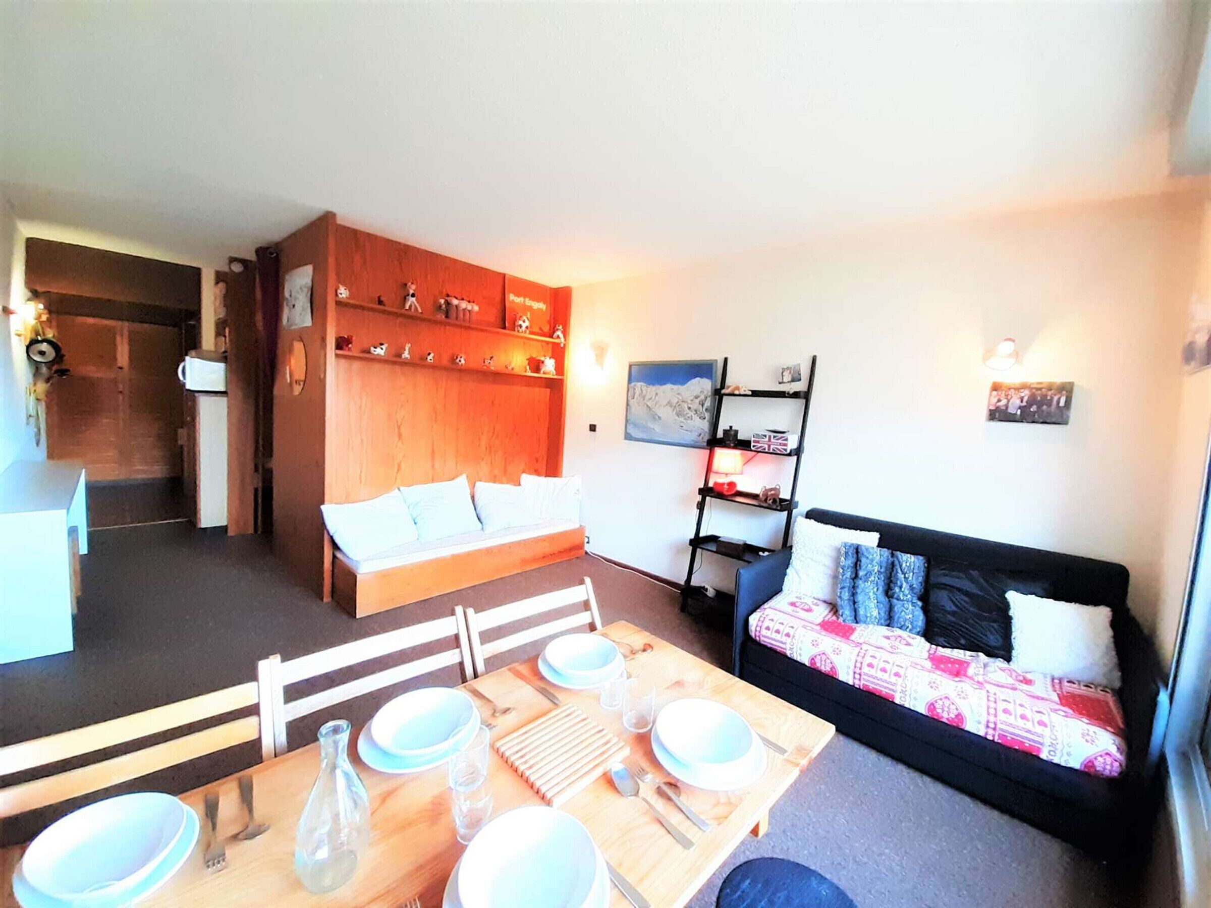 A compact living space with a dining area, a sofa, and a bookshelf.