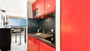 Una cucina moderna con pensili rossi, un piano di lavoro nero e un lavandino in acciaio inossidabile.