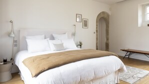 A bedroom with a large bed, a bedside table, a lamp, and a bench. - Château Toulouse-Lautrec Malromé (Saint-André-du-Bois)