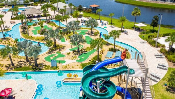 Parque acuático con una piscina grande, toboganes y vistas al río.