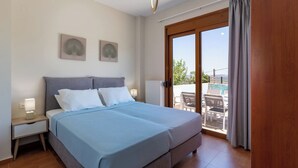 A bedroom with a bed, nightstands, and a view of an outdoor patio.