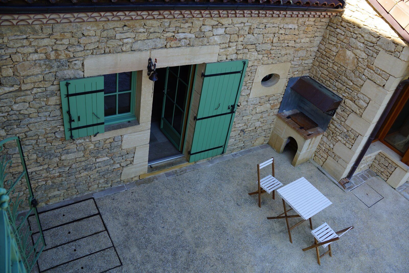 A stone building with a small patio area featuring a table and two chairs.