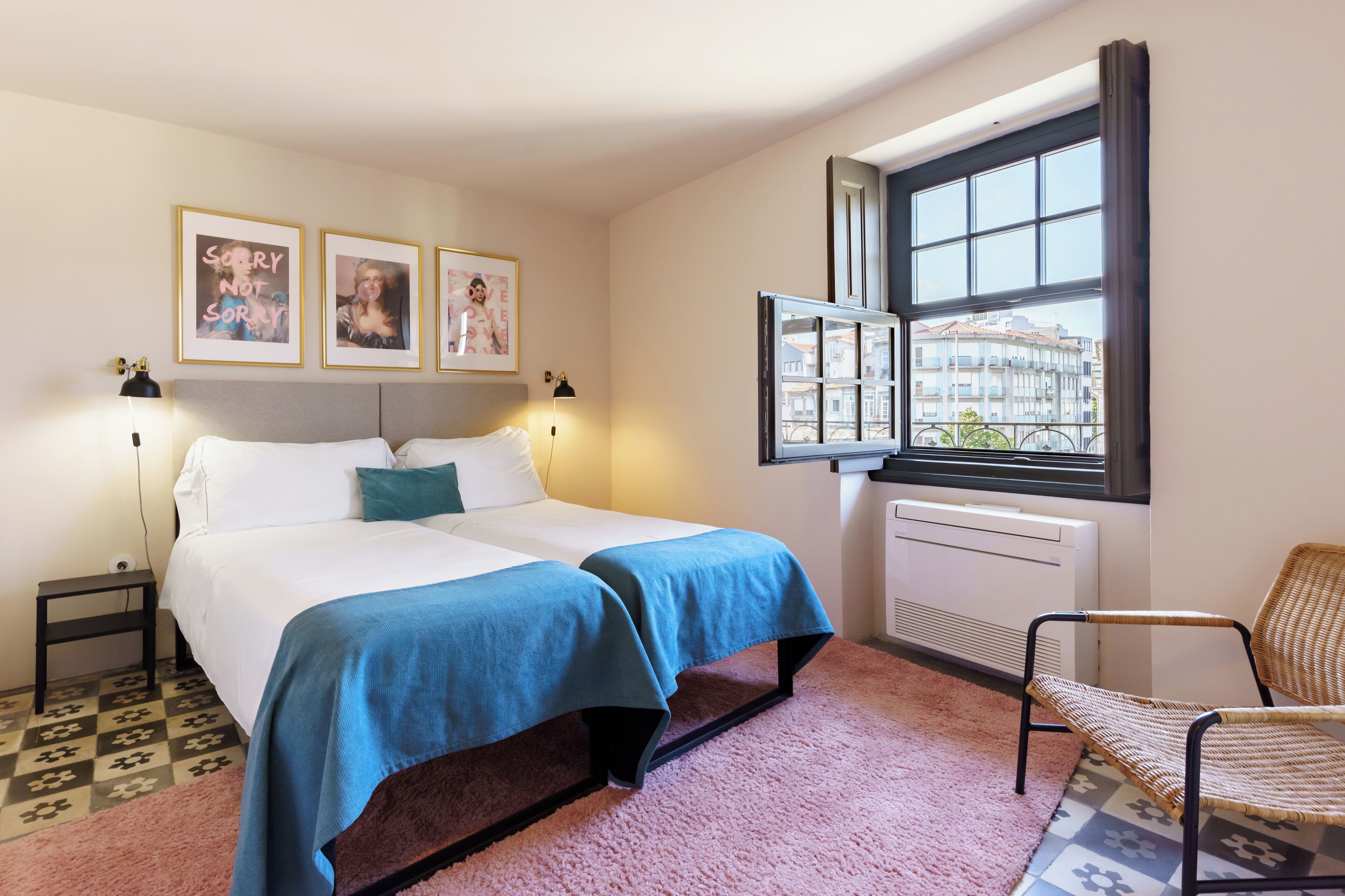 Un dormitorio con dos camas, una ventana con vistas, una silla y un radiador.