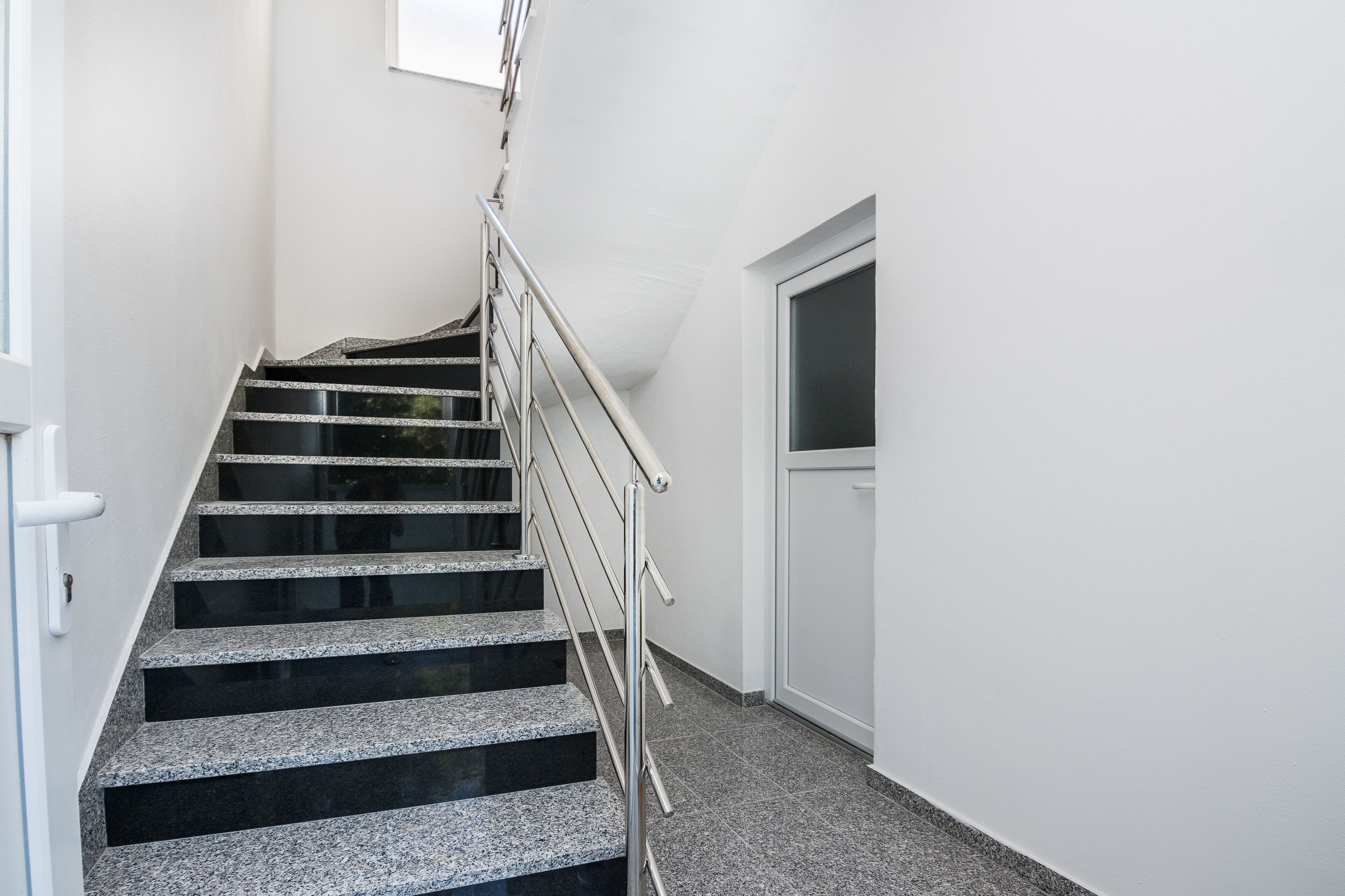 A staircase with metal railings and a door at the top.