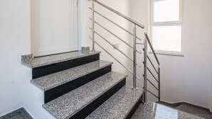 A staircase with granite steps and a metal handrail, leading to a door. - Apartments Krpan (Vir)
