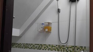 Ein Badezimmer mit Dusche, Seifenspender und Handtuchhalter.
