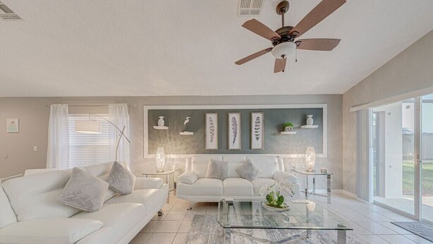 A modern living room with a white sofa, a glass coffee table, and a ceiling fan. - ⭐Modern & Luxurious 4 Bed Home | Gated Resort | SOUTH Facing Pool | Mins to WDW⭐ (Davenport)