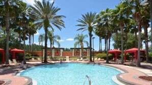A swimming pool with a no diving sign, surrounded by palm trees and red umbrellas. - ⭐Modern & Luxurious 4 Bed Home | Gated Resort | SOUTH Facing Pool | Mins to WDW⭐ (Davenport)
