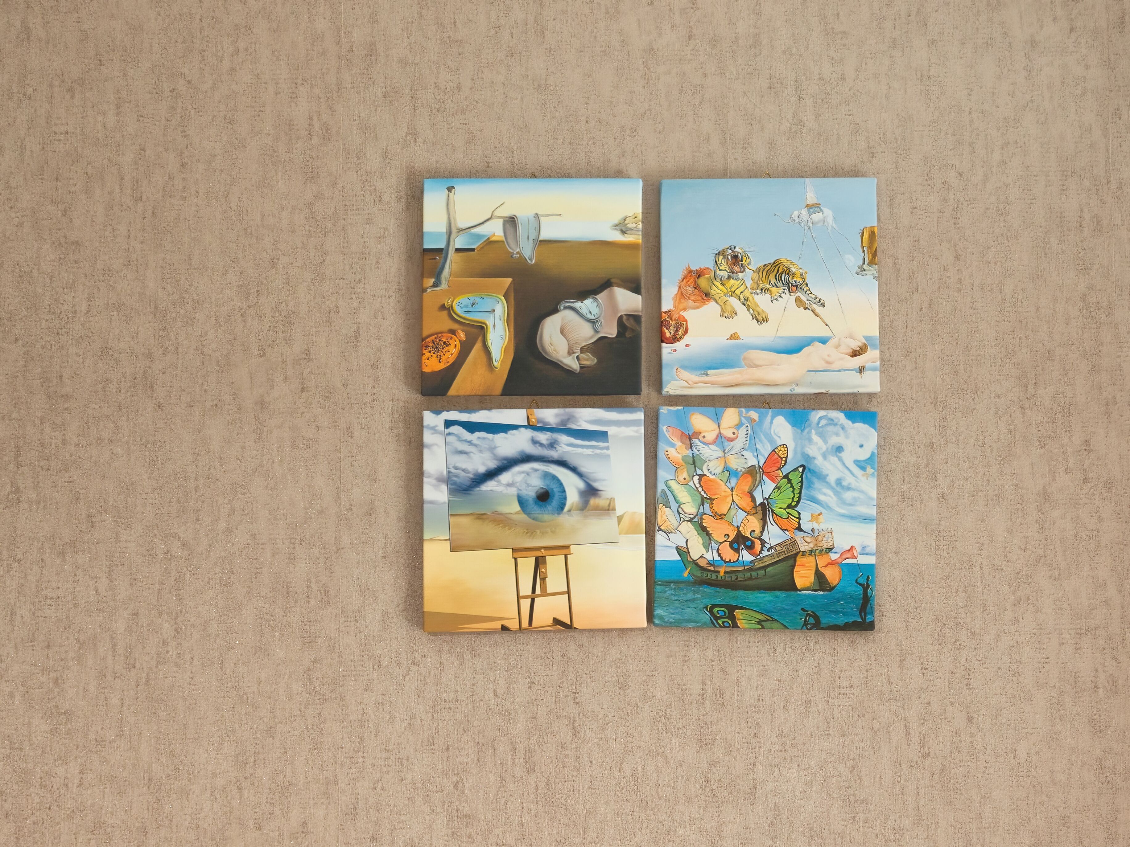 A wall with four paintings: a melting clock, a woman with a tiger, a surreal eye, and a boat with butterflies.