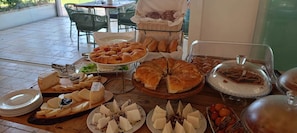 Una taula de buffet amb diferents formatges, pa i pastissos.
