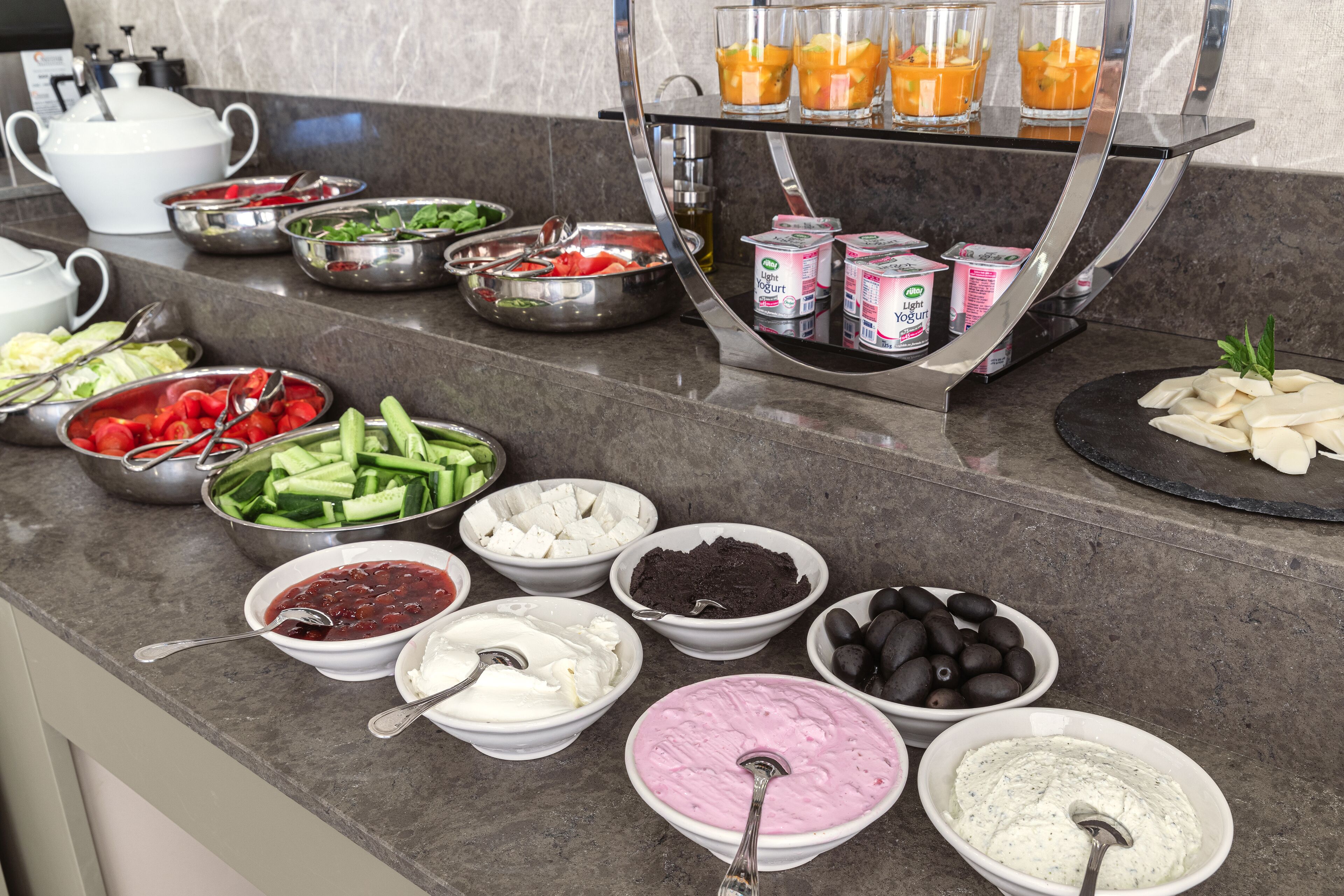 Buffet variado com frutas, legumes, queijos e patês.