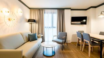 Una sala de estar moderna con un sofá, una mesa redonda de centro y un comedor con sillas y una mesa.