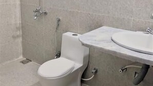 A bathroom with a shower, toilet, and sink. - Hotel Rose Inn (Lahore)