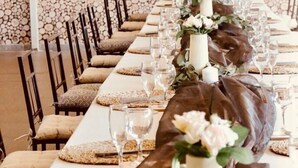 A long dining table with chairs, decorated with floral arrangements and candles. - ZAI OAT HOTEL (Makhuduthamaga)