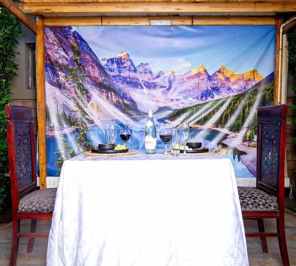 Una mesa para dos con un hermoso paisaje de montañas, una botella de agua y dos vasos.