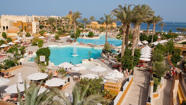 A resort with multiple swimming pools, palm trees, and a view of the sea. - Makadi Family Star Hotel (Makadi Bay)