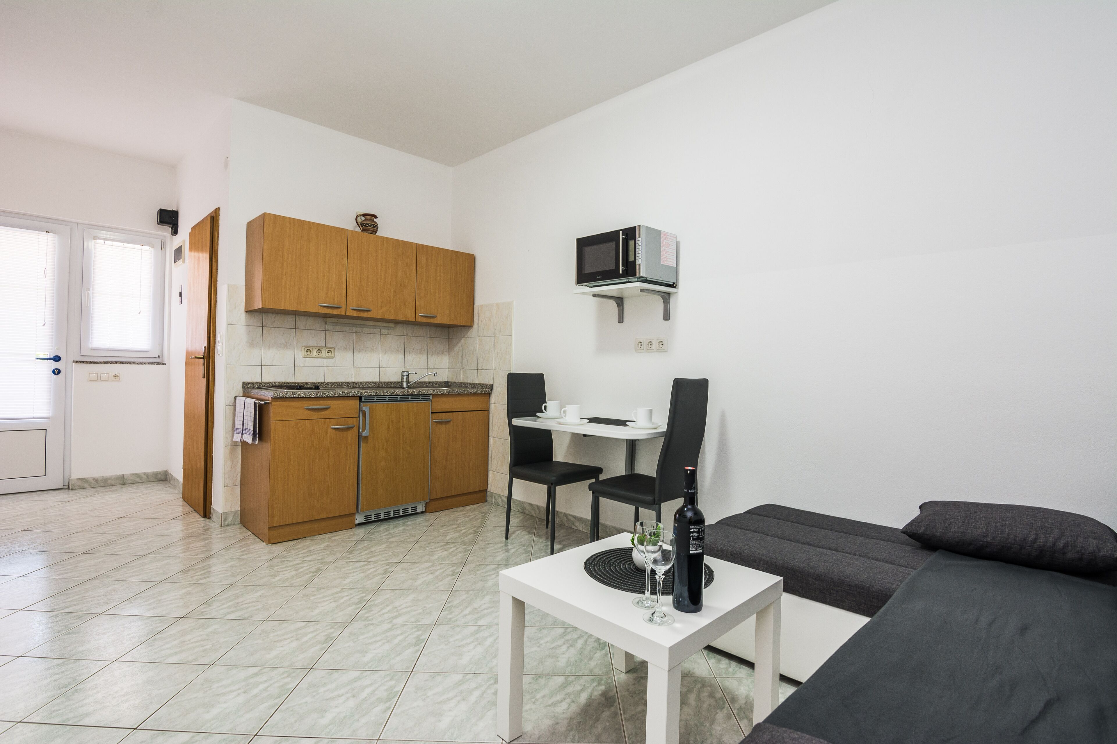 A compact living space with a kitchenette, a dining area, and a seating area.