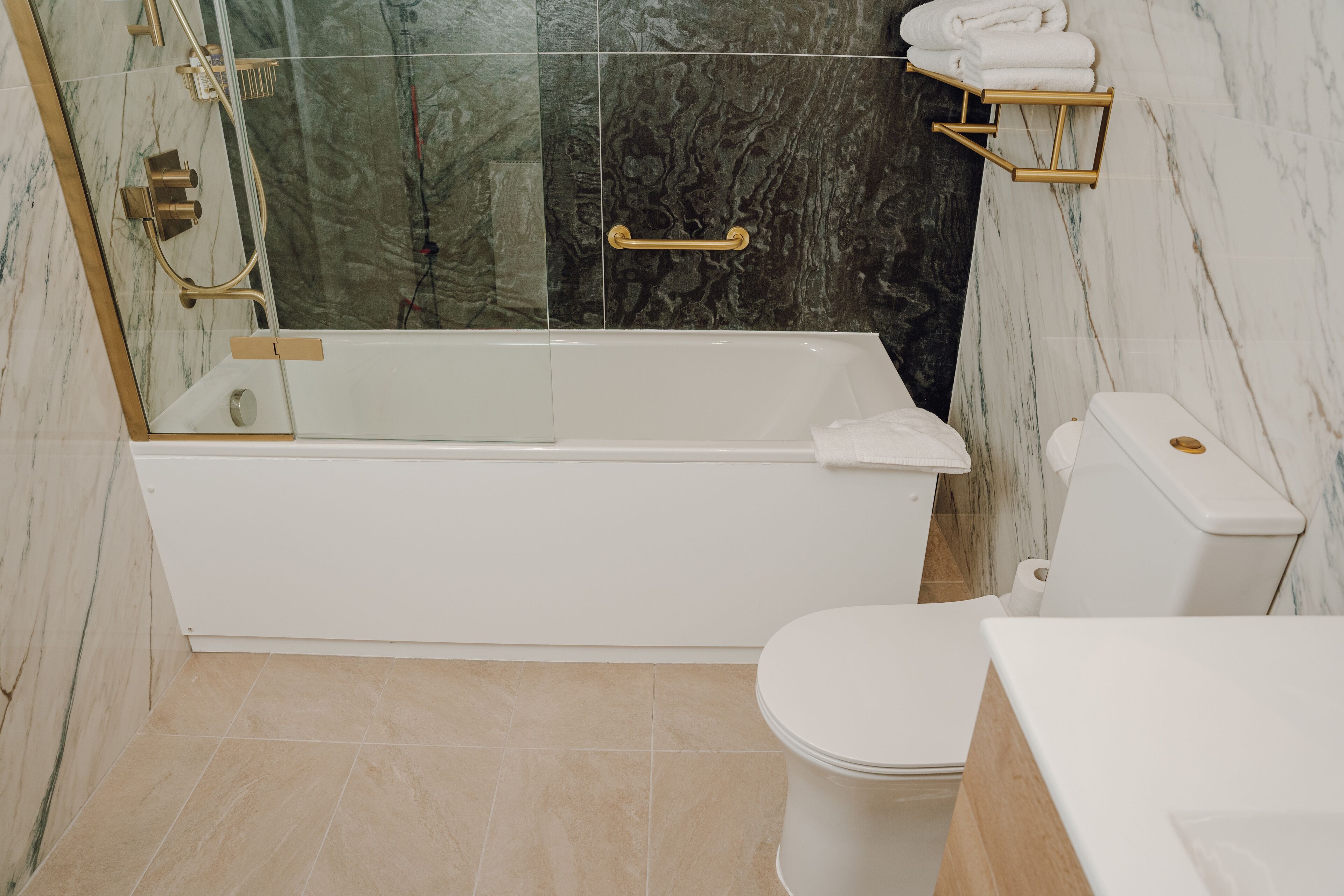 Un baño con bañera, inodoro y cabina de ducha de vidrio.