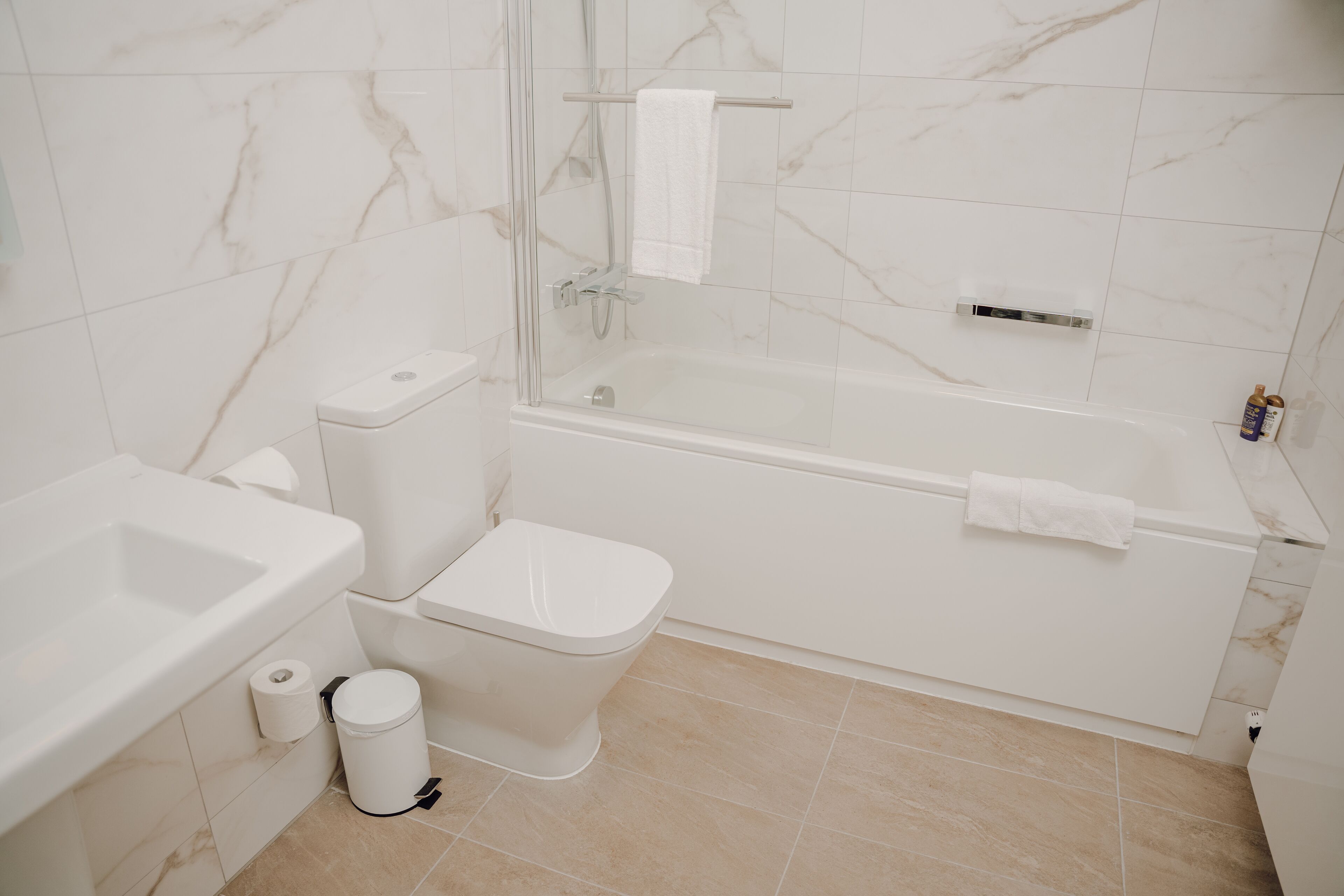 Ein modernes Badezimmer mit Toilette, Waschbecken und Badewanne.