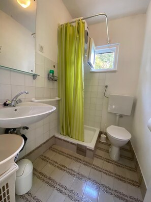 Une petite salle de bain avec un lavabo, des toilettes et une baignoire.