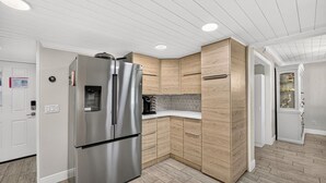 A modern kitchen with a stainless steel refrigerator, wooden cabinetry, and a built-in water dispenser. - Sugar Beach-C16 Unique in the best way. Just updated be first to enjoy upgrades. (Panama City)