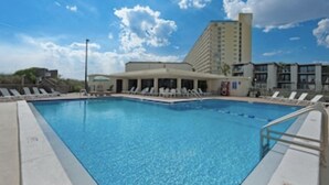 A swimming pool with lounge chairs and a building in the background. - Sugar Beach-C16 Unique in the best way. Just updated be first to enjoy upgrades. (Panama City)
