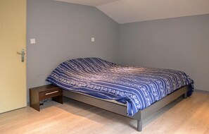 Ein Schlafzimmer mit einem Bett, einem Nachttisch und Holzboden.