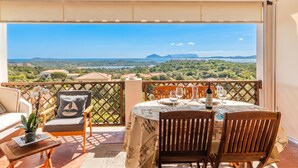 A balcony with a table set for two, overlooking a scenic landscape. - La Casa Di Farina (Arzachena)