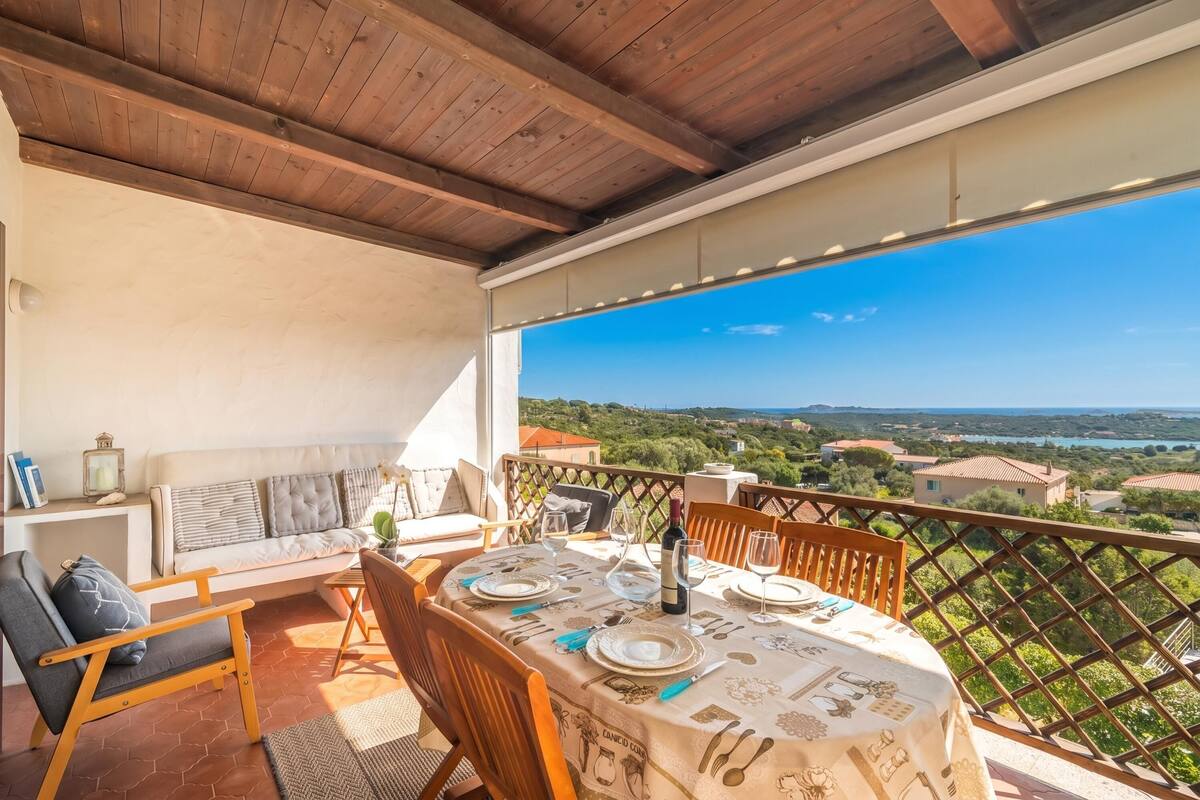 Eine Terrasse mit Esstisch, einer Sitzecke und Blick auf die Landschaft.
