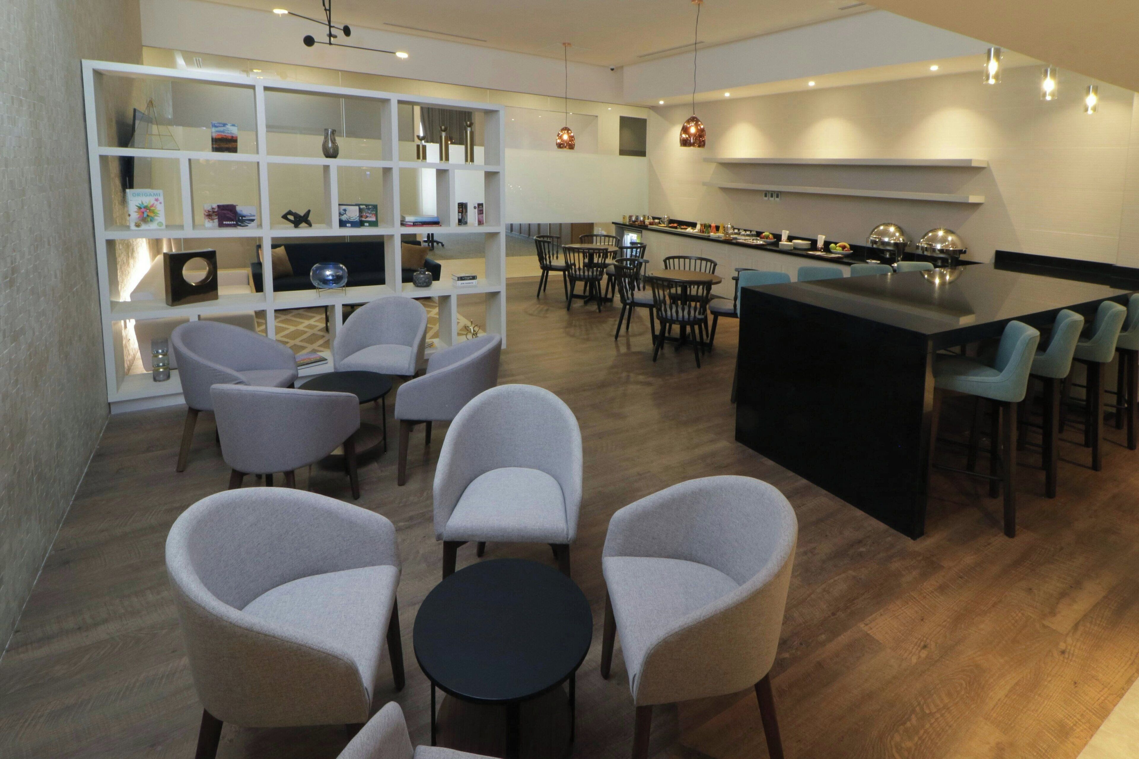 En modern inredning med matplats, bar och sittgrupp.