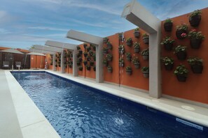 Piscine extérieure, parasols de plage, chaises longues