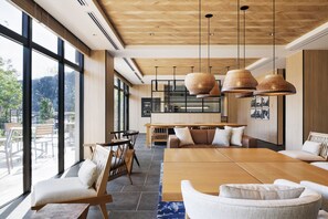 A modern interior with a large wooden dining table, comfortable seating, and large windows offering a view of the outdoors. - Fairfield By Marriott Hyogo Tajima Yabu (Yabu)