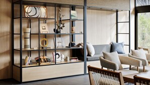 Una sala moderna con una estantería empotrada, un sofá y una mesa de comedor.