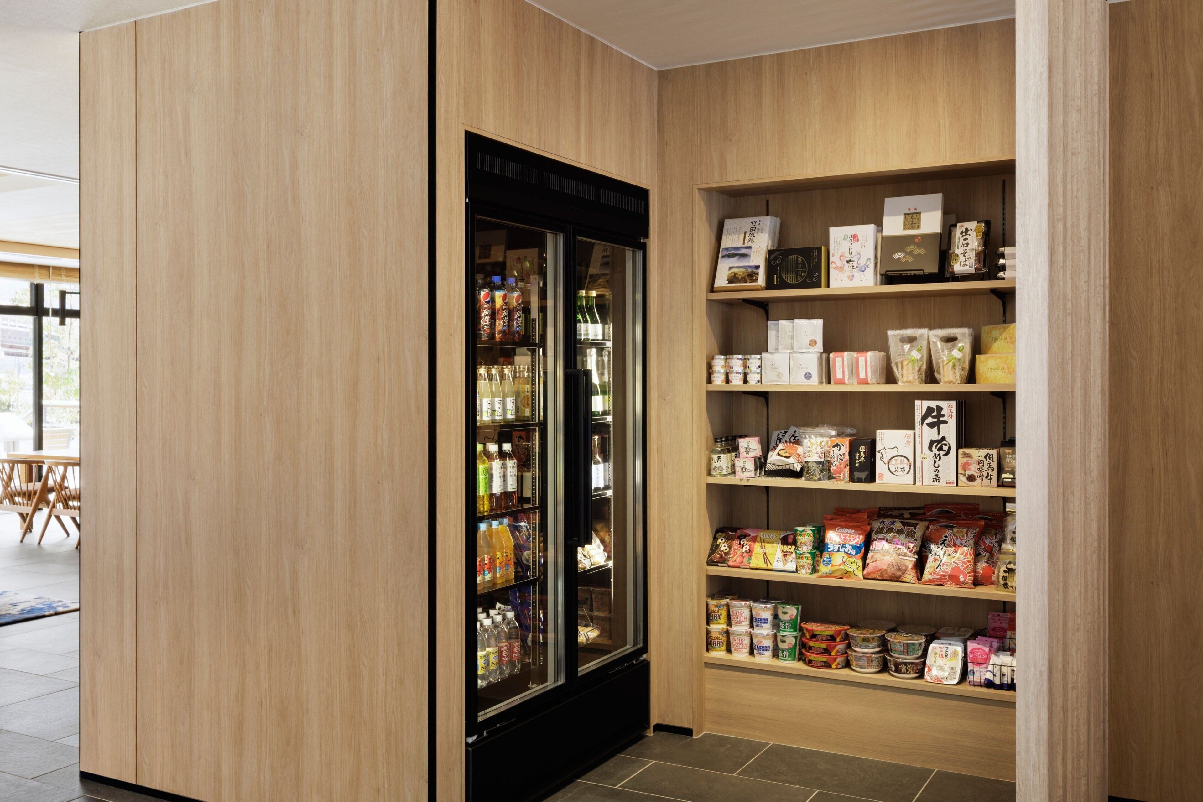 A vending machine with a variety of beverages and snacks, and shelves stocked with packaged goods.