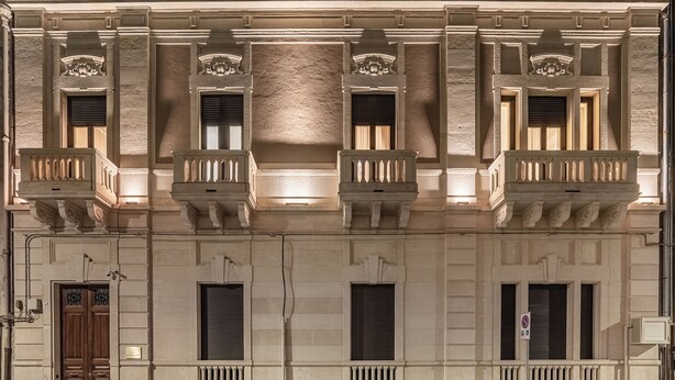 A building with a classical facade, multiple balconies, and a prominent central column.