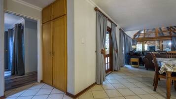 A spacious living area with a dining table, a sofa, and a wooden cabinet.