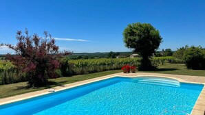 Une piscine rectangulaire à l’eau d’un bleu limpide, entourée d’une terrasse carrelée.