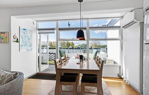 Una cucina moderna con un ampio tavolo da pranzo, una lampada a sospensione e vista all'esterno.