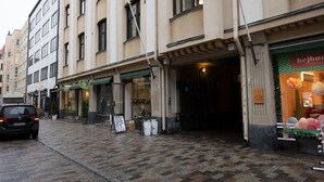 Una vista di strada con una fila di edifici, tra cui un negozio con il cartello 
