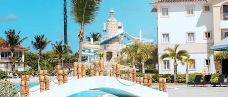A resort with a water slide, a pool, and a building with balconies.