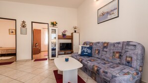 A modern living room with a sofa, a coffee table, and a TV. - Apartment Steindl (Vir)