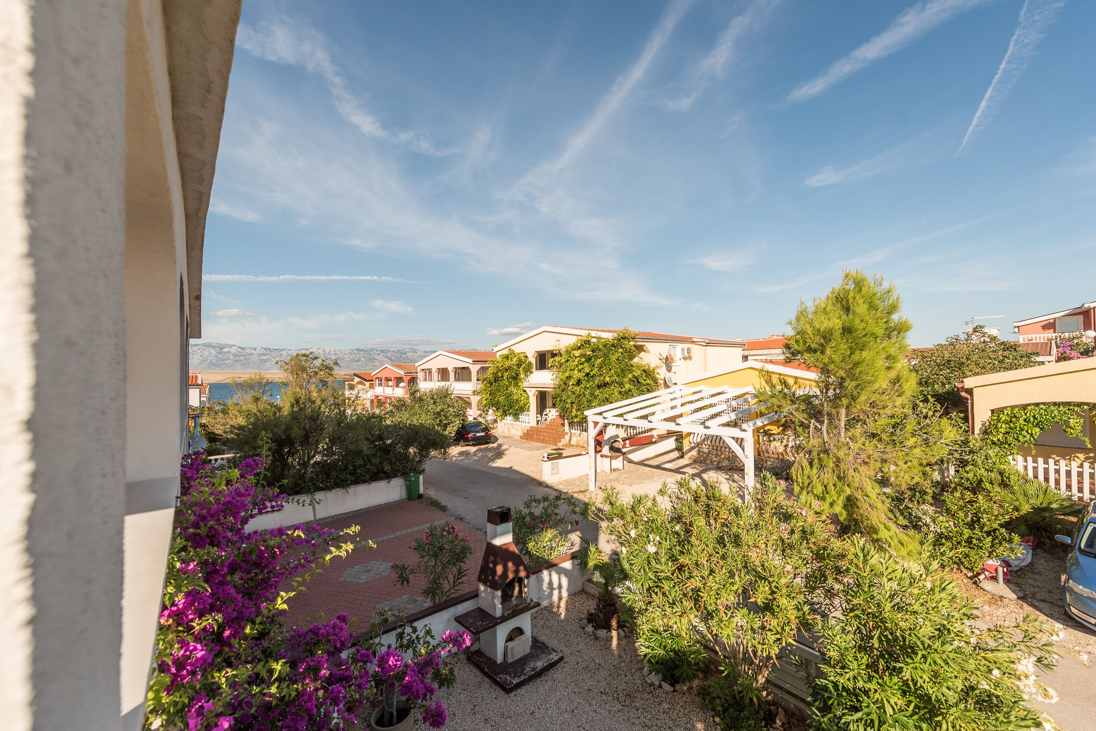 A residential area with a patio, outdoor seating, and a view of neighboring houses.