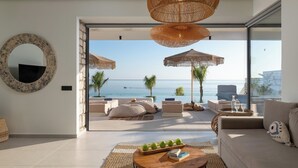 Un salon moderne avec un canapé, une table basse et une vue sur la mer.