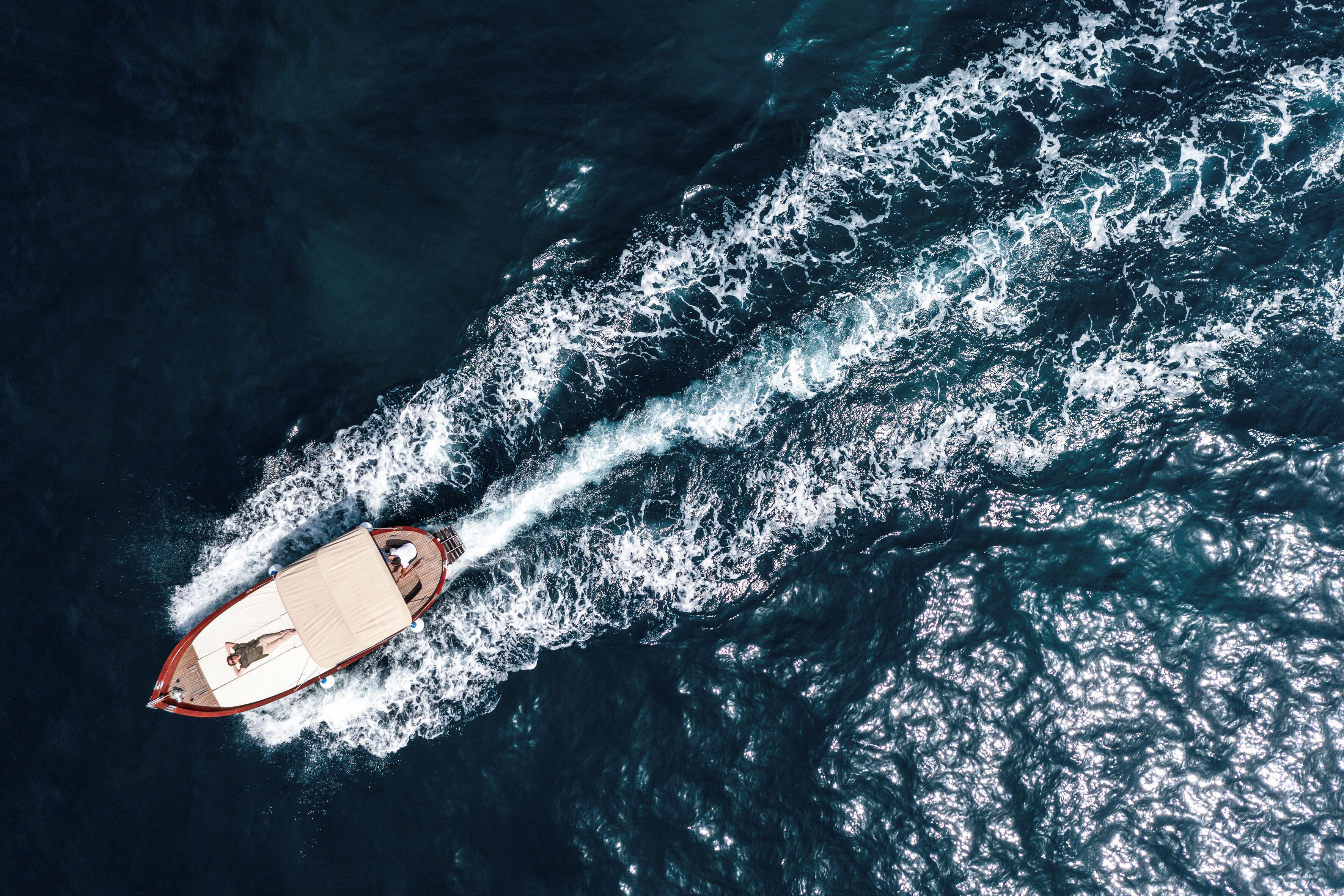 A boat moving through the water, creating a wake behind it.