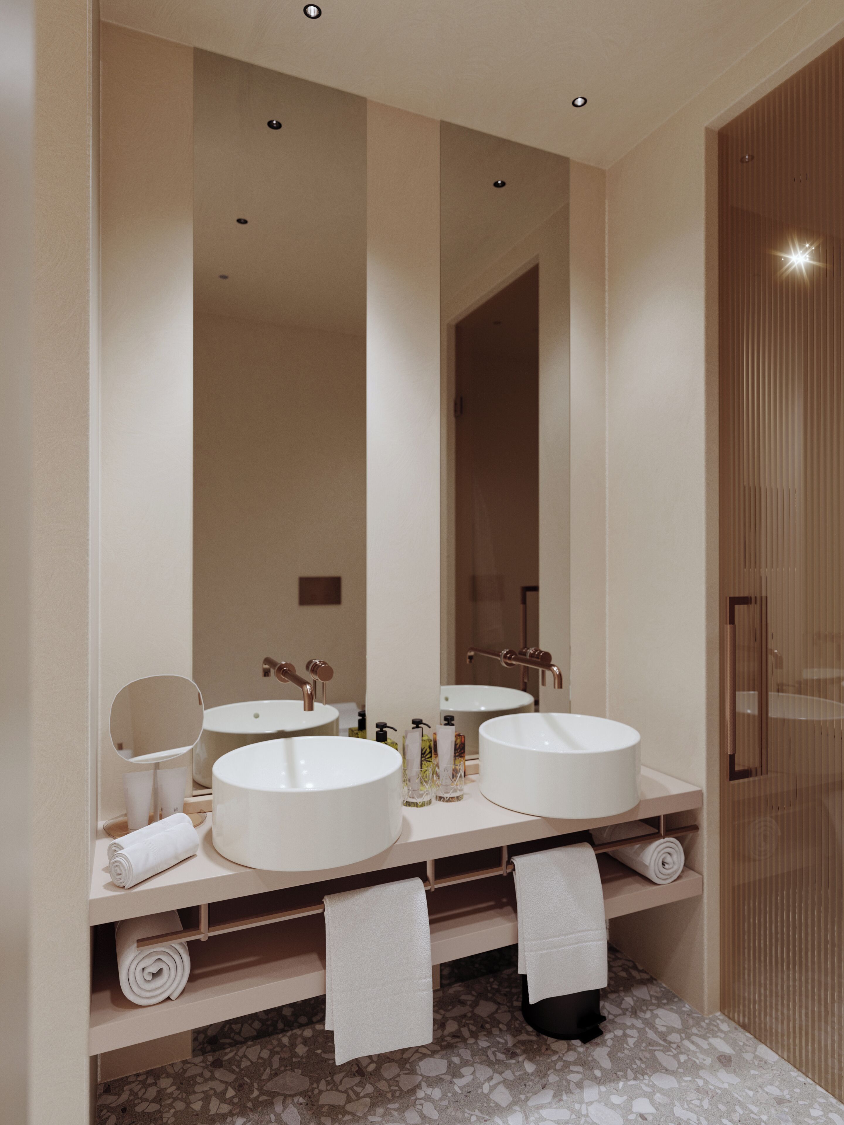 Une salle de bain moderne avec deux grands lavabos blancs, un miroir rond et une porte en bois.
